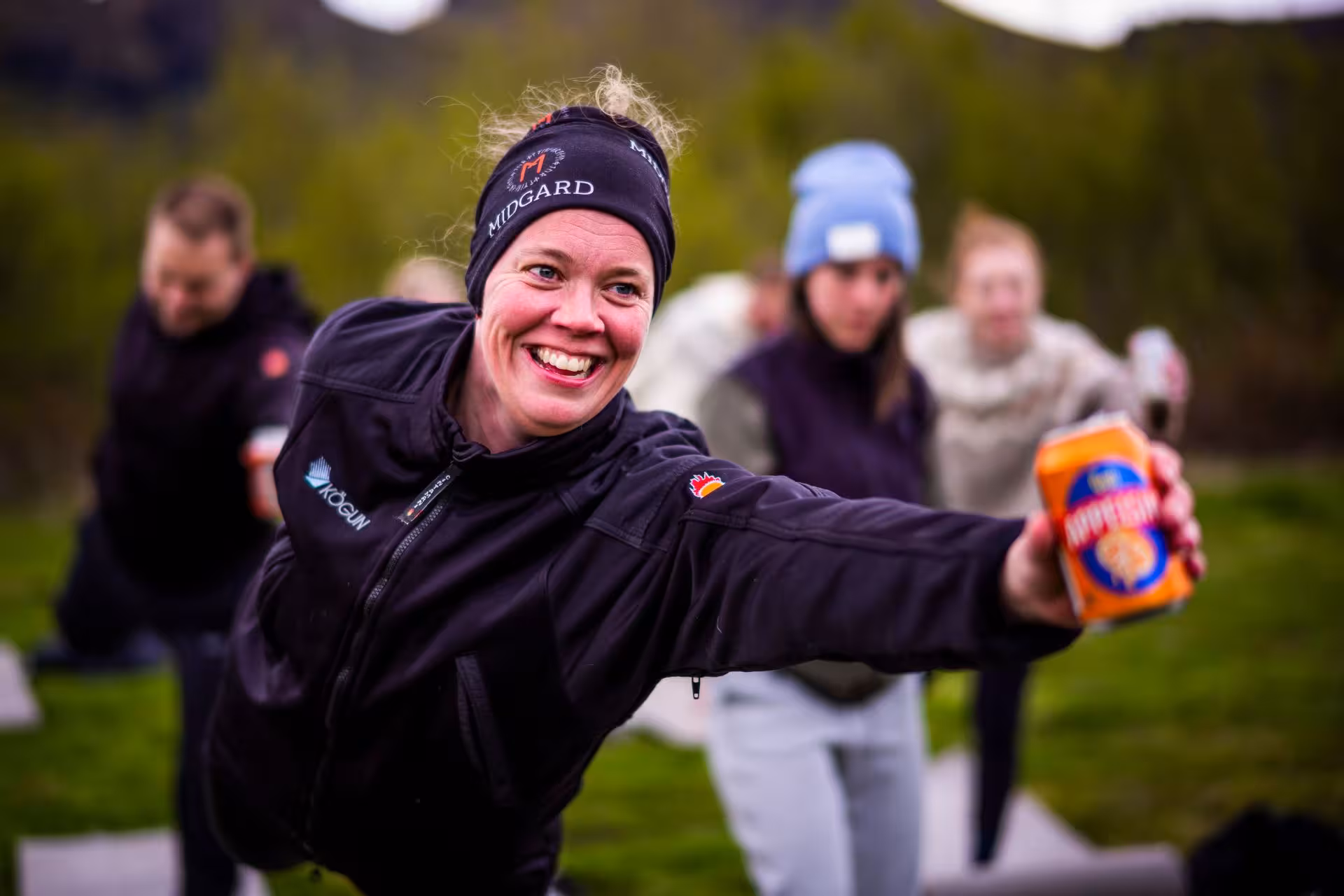 Smiling female guide holding orange snack box during Fimmvorduhals guided hike in Iceland