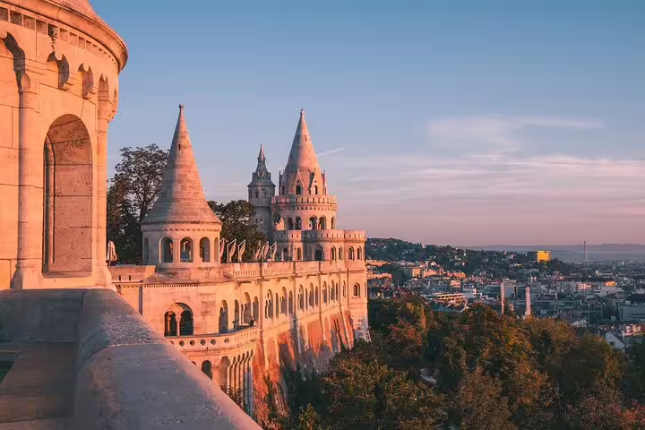 Fisherman's Bastion towers at golden hour overlooking Budapest cityscape