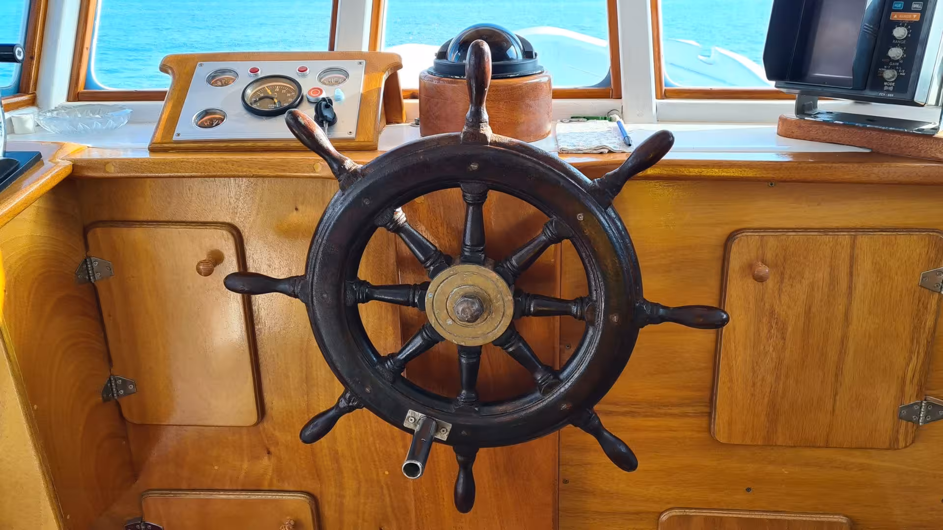 Traditional wooden helm of a fishing boat on a tour from Calasetta to San Pietro Island, offering a nautical experience.