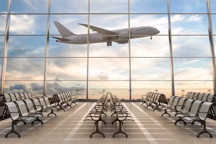 Airplane taking off viewed from modern Fiumicino Airport terminal, symbolizing the start of your Rome journey.