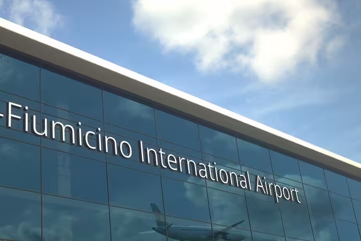 Glass facade of Fiumicino International Airport, promoting efficient airport transfer services.