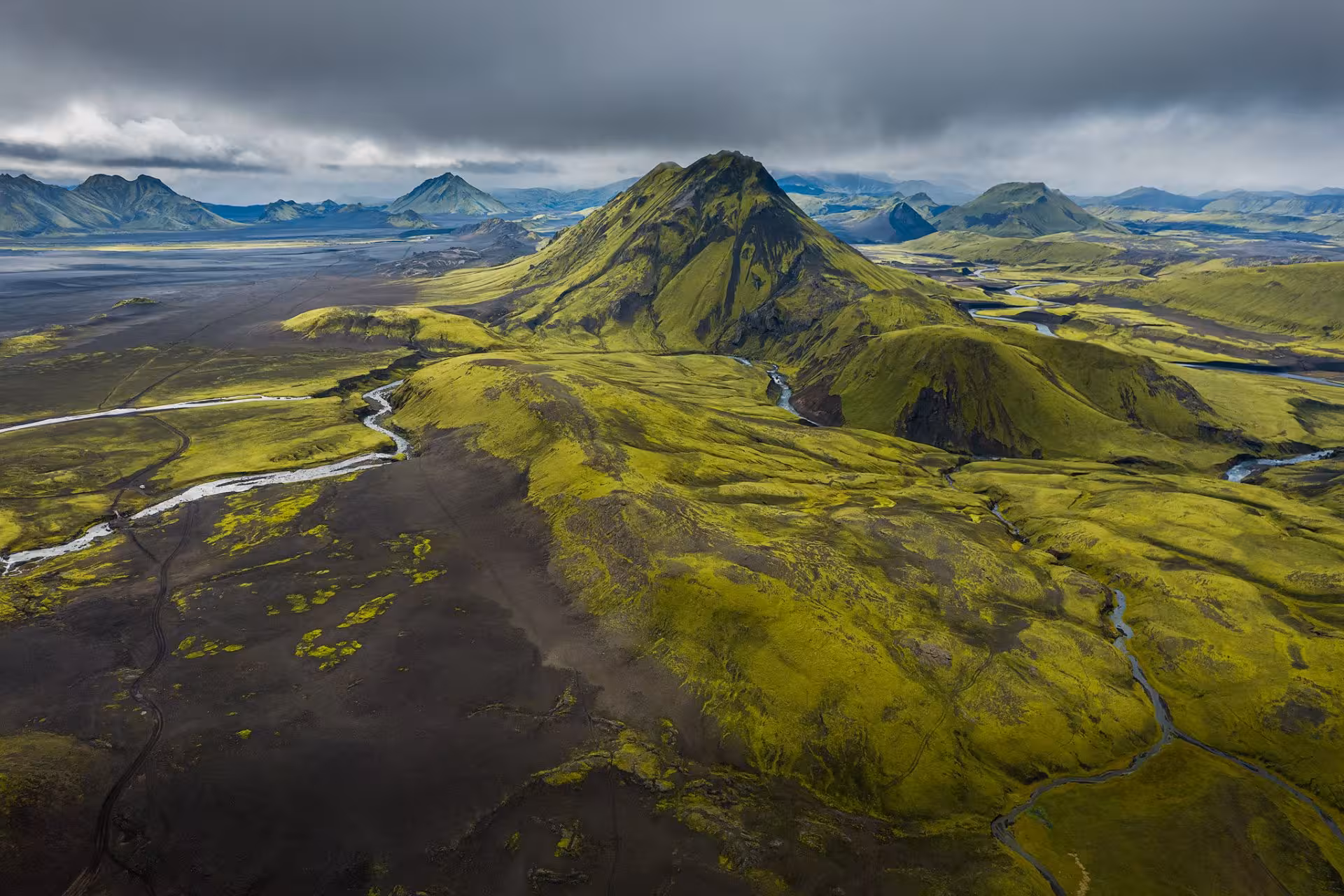Aerial view of moss-covered volcanic mountains and winding rivers in Fjallabak Nature Reserve, Iceland