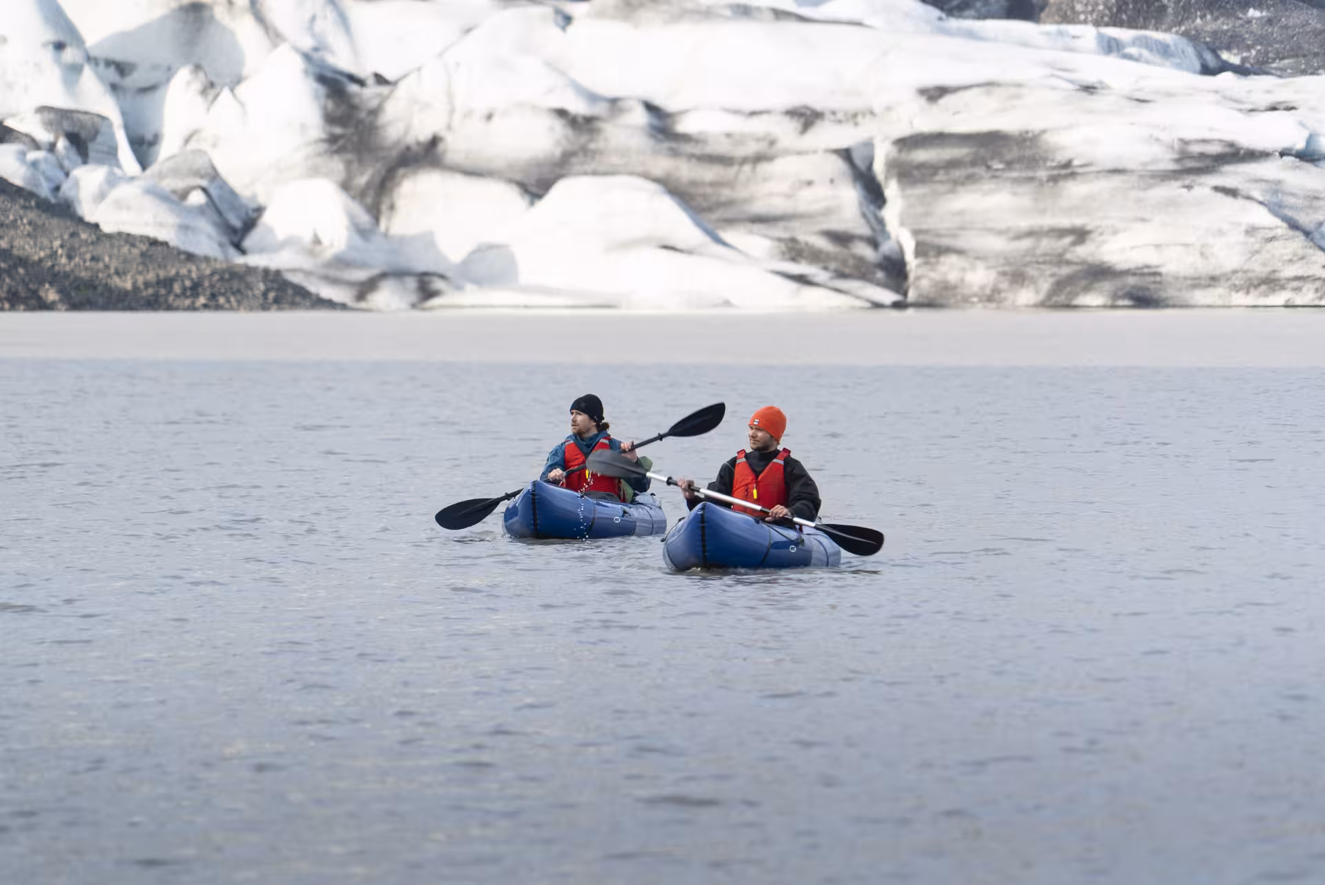 Two kayakers paddling on Fláajökull glacier lagoon, Iceland, on a full-day kayak and glacier hike combo tour