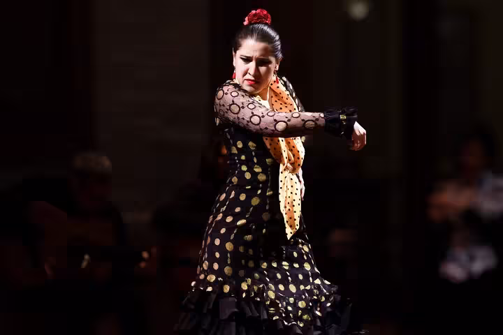 Passionate flamenco dancer in a polka dot dress performing at a live show in Barcelona, embodying traditional Spanish art.
