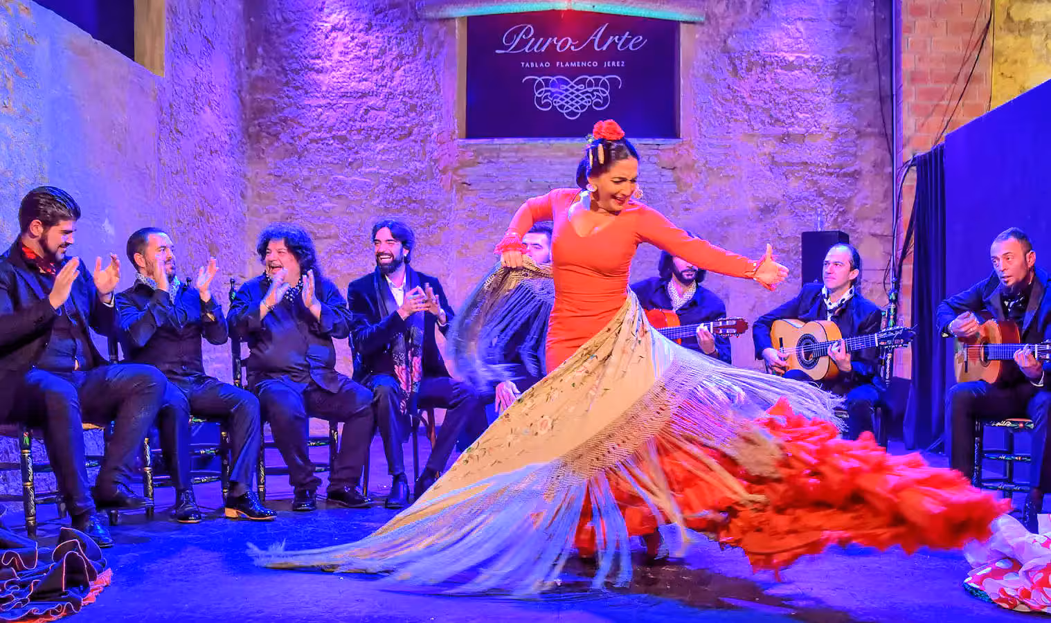 Vibrant flamenco performance with a dancer in red dress captivating the audience in a lively cultural setting.