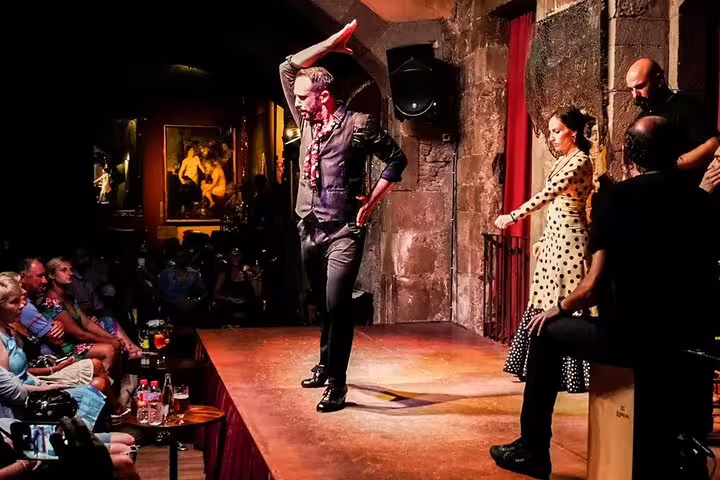 Flamenco dancers perform passionately on stage in a cozy Barcelona venue, offering an authentic tapas and wine experience.