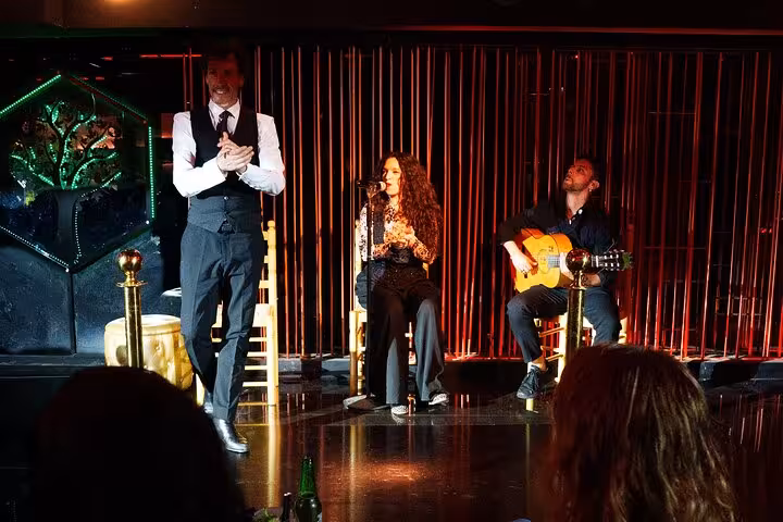 Flamenco performers including a singer, guitarist, and dancer on stage in Barcelona, offering an authentic cultural experience.