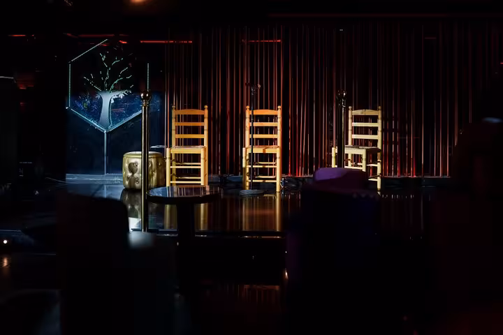 Cozy flamenco stage set with wooden chairs and intimate lighting in Barcelona's authentic live show venue.