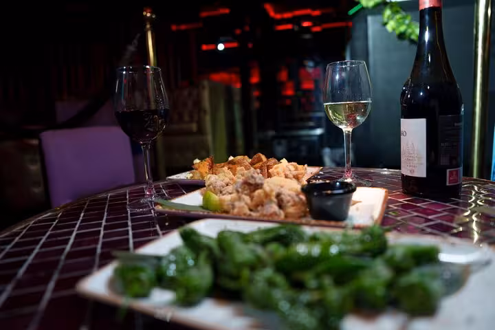 Enjoy a table set with fine wine and delicious tapas, perfect for an authentic Flamenco show experience in Barcelona.