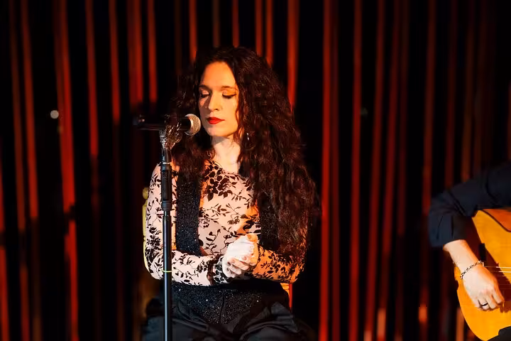 Flamenco singer passionately performing on stage during an authentic live show in Barcelona.