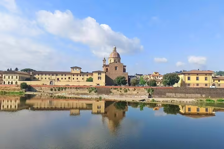 Riverside view of historic Florence palaces and church dome reflected in the Arno, seen on private Livorno to Chianti wine tours