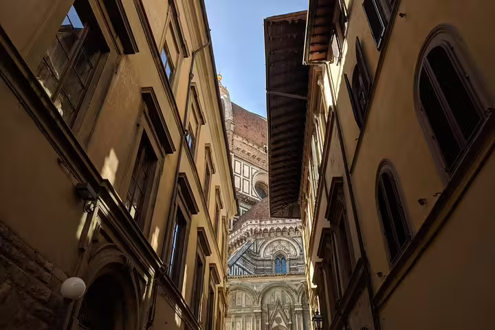 Narrow alleyway in Florence revealing the ornate facade and dome of the Florence Cathedral