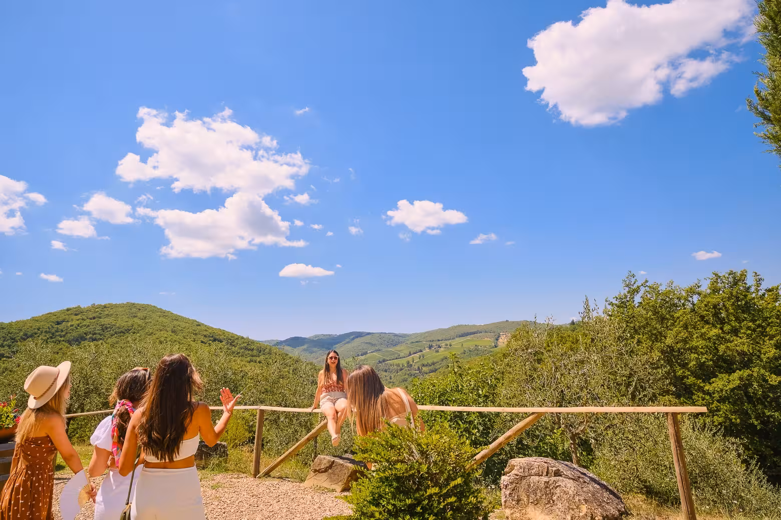 Group enjoying panoramic views of Chianti hills under a bright blue sky on a Florence to Chianti wine tour.