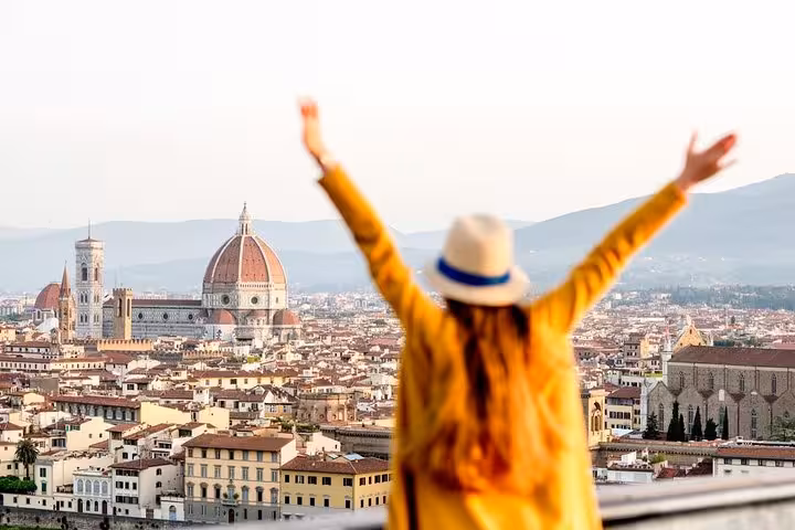 Traveler enjoying panoramic view of Florence's iconic Duomo and skyline on Accademia & Uffizi small group tour.