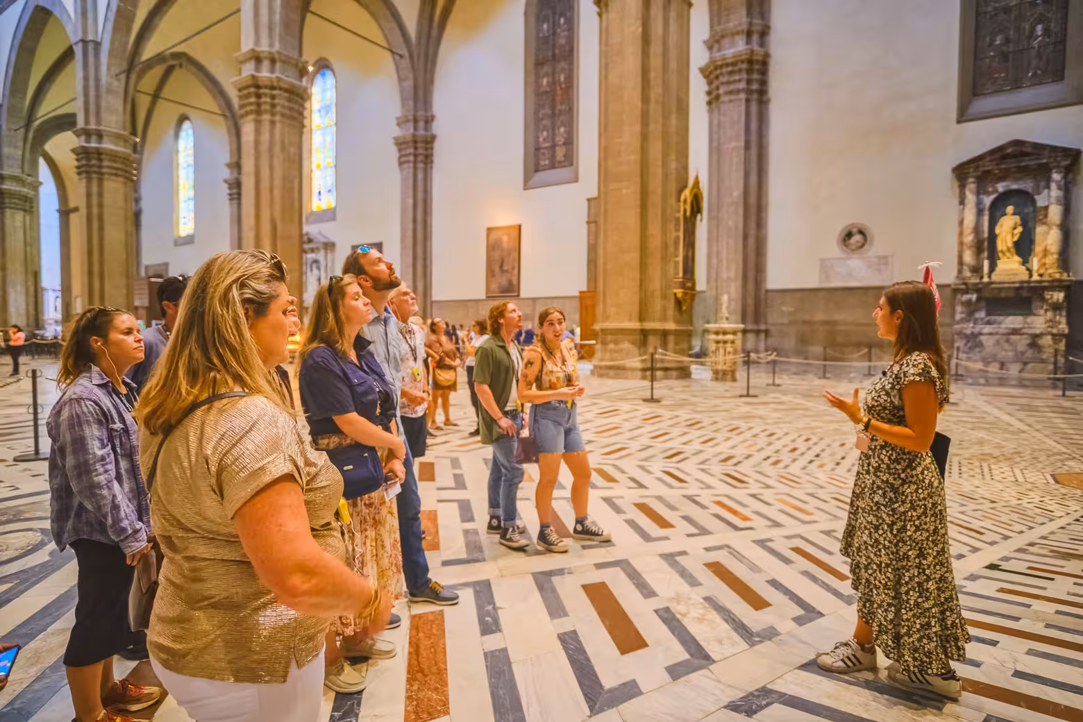 Visitors attentively listening to a guide inside the Florence Duomo Cathedral on a skip-the-line tour.