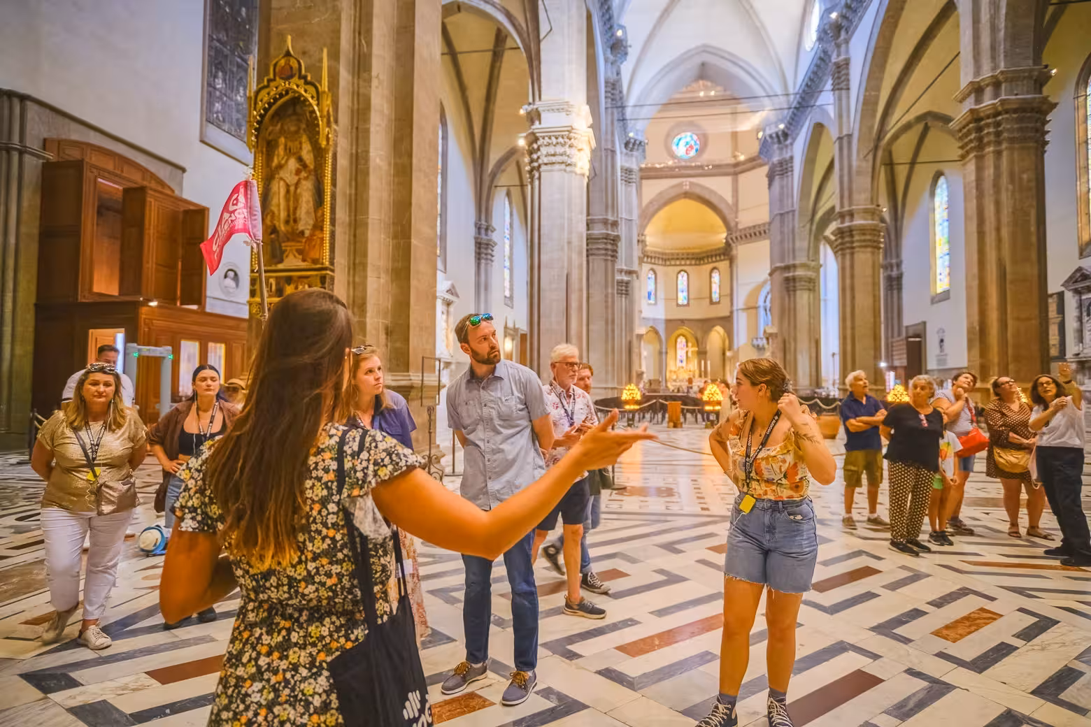 Group tour inside Florence Duomo Cathedral, with guide explaining the cathedral's rich history and architecture.