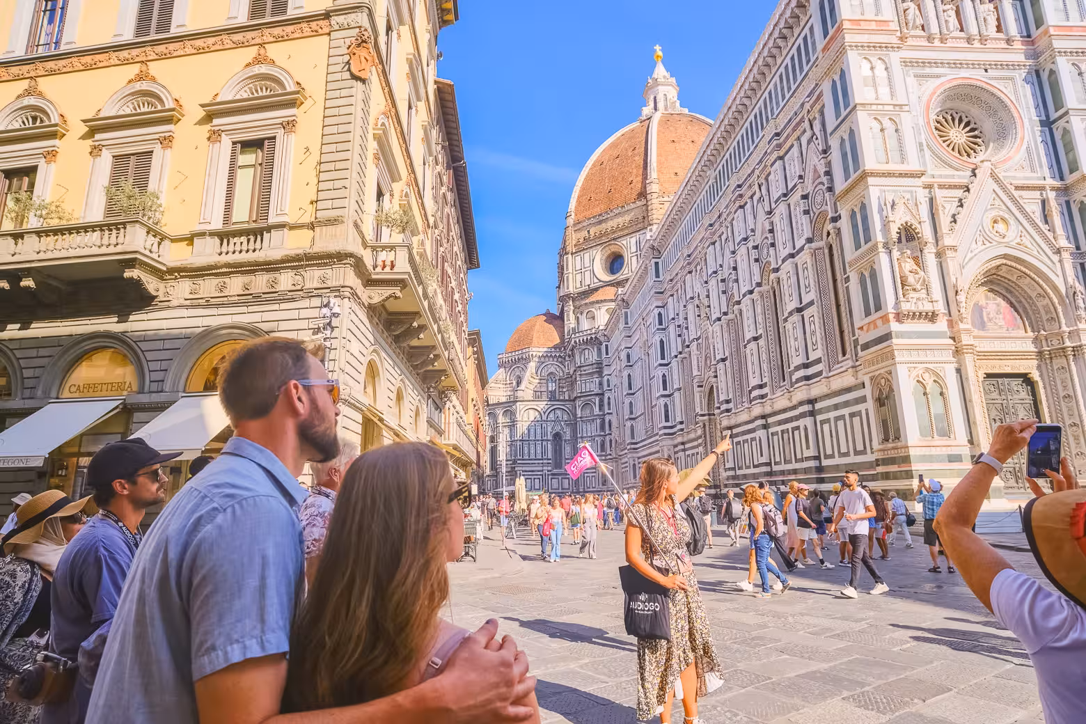 Tourists admire Florence's Duomo Complex with its stunning architecture and the iconic Brunelleschi's Dome in view.