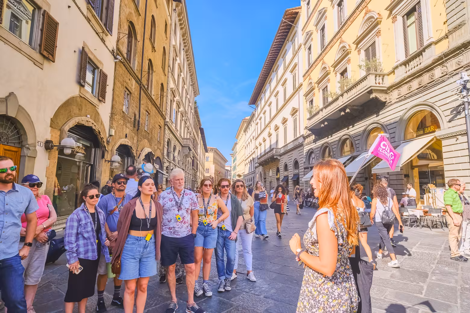 A guided tour group listens attentively while exploring the historic streets around Florence's Duomo Complex.