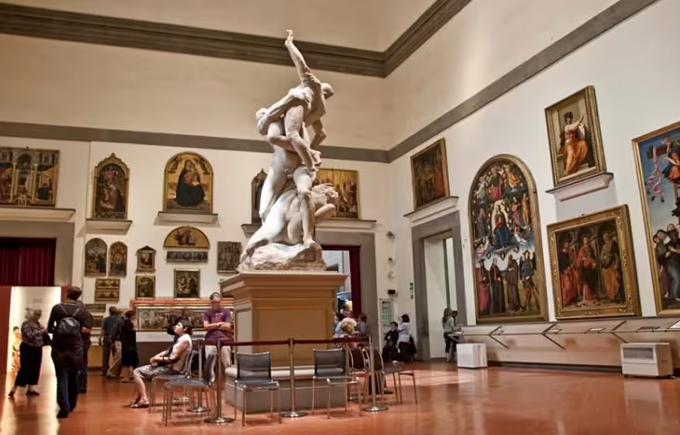 Visitors admire Renaissance masterpieces and marble sculpture inside a Florence gallery on a semi-private Rome day trip
