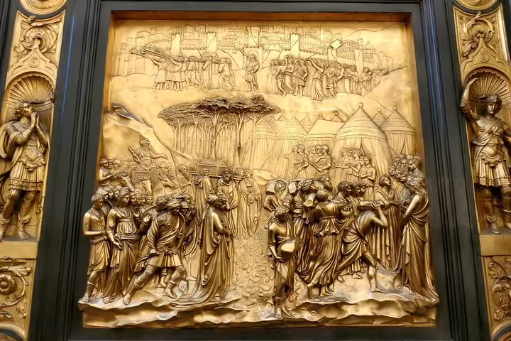 Golden bronze relief panel depicting biblical scenes with multiple figures, part of Florence Baptistery's Gates of Paradise