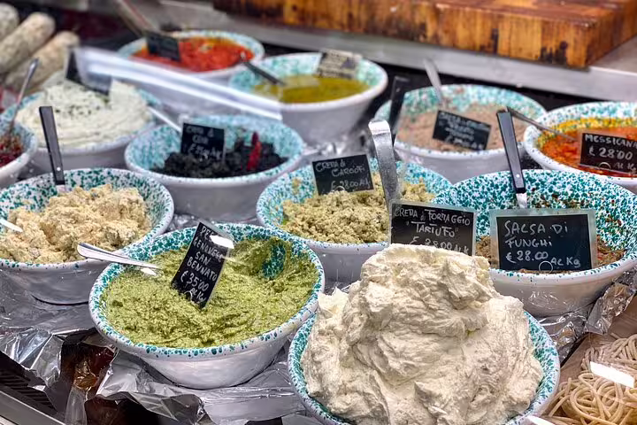 Colorful bowls of fresh Italian spreads and sauces including truffle cheese and mushroom salsa at a Florence market