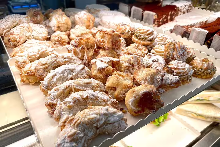 A bakery display tray filled with powdered sugar-dusted Florentine pastries perfect for a Florence street food tour