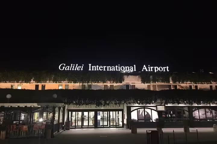 Galilei International Airport illuminated at night, highlighting seamless private transfers from Florence to Pisa.
