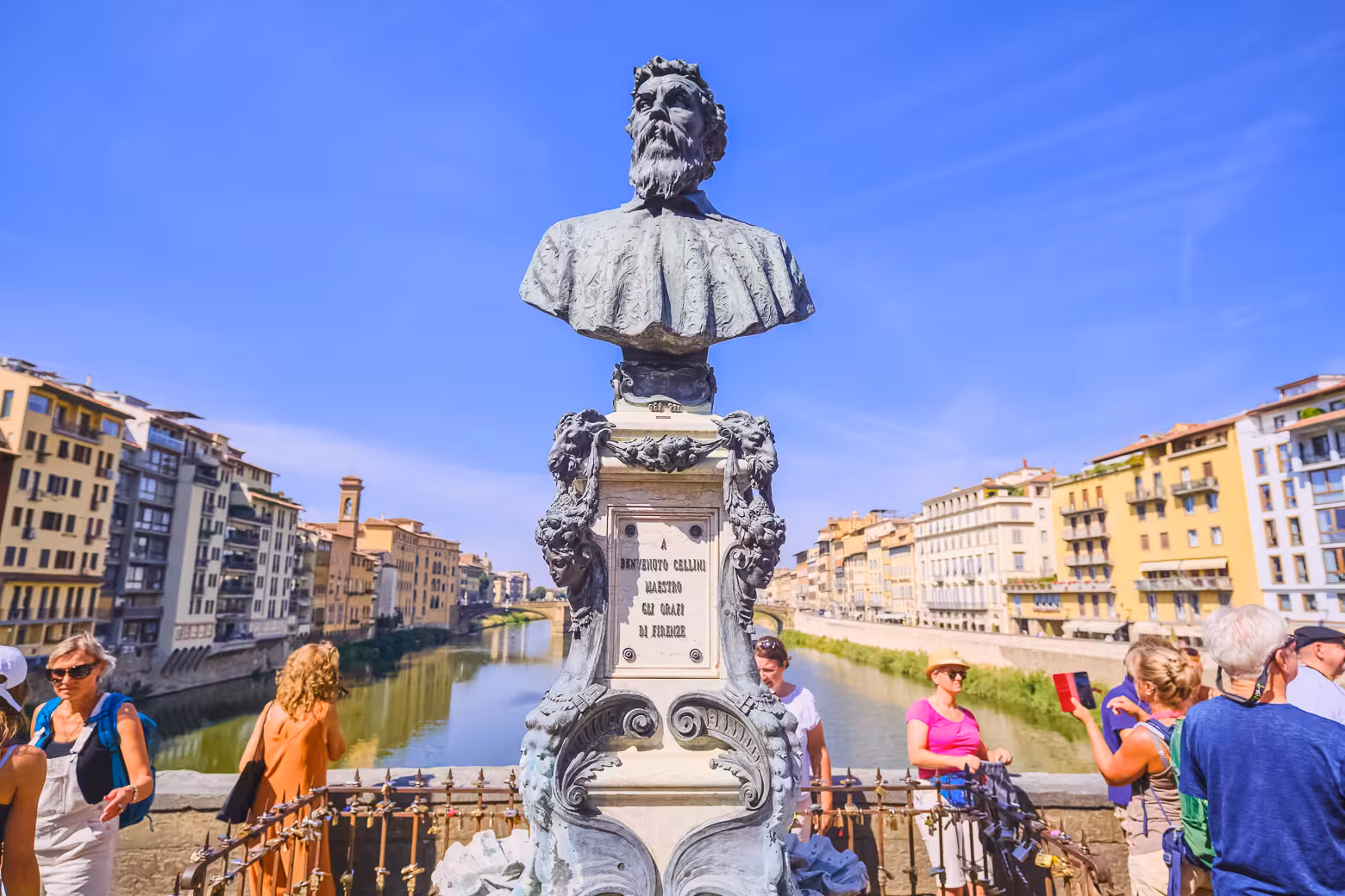 Tourists admire the Benvenuto Cellini bust on Ponte Vecchio during a full-day Florence shore excursion from Livorno.