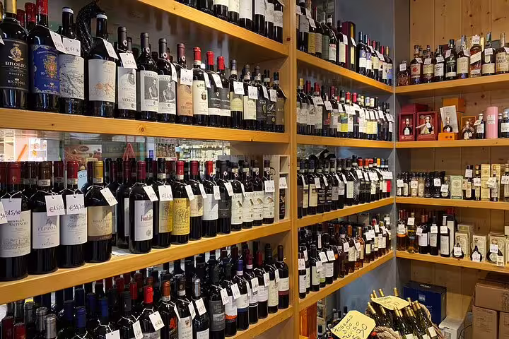 Wooden shelves lined with diverse Italian wine bottles at a local Florence shop on a street food tour