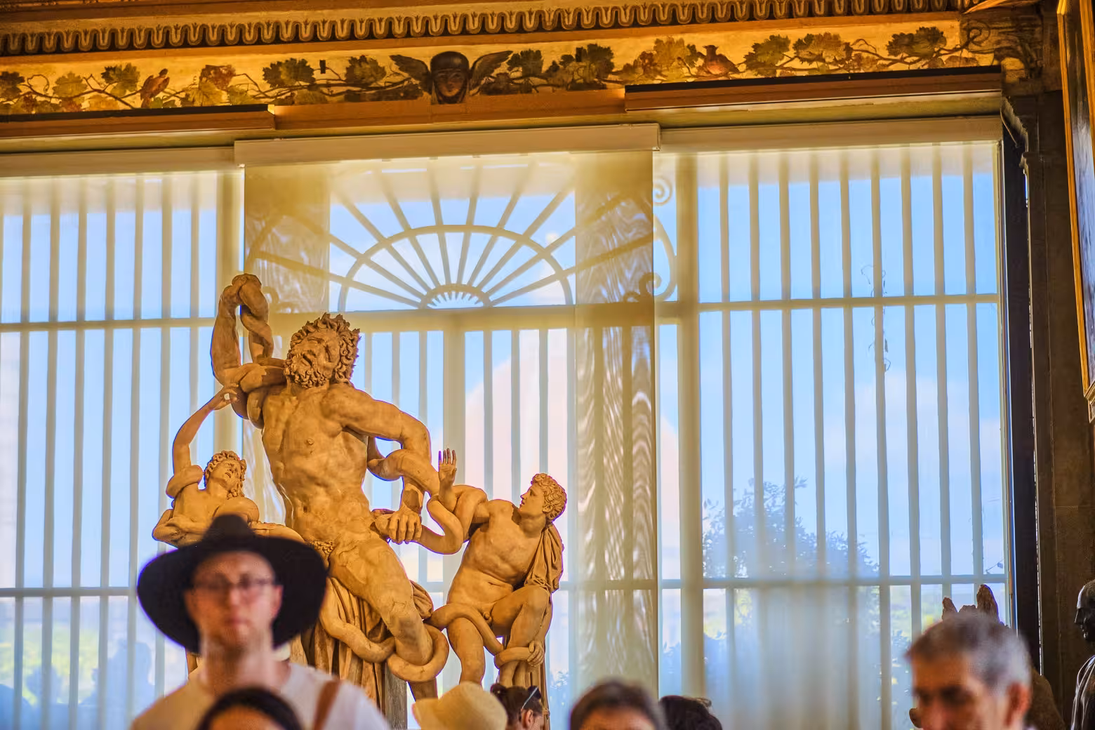 Tourists explore Laocoön and His Sons sculpture at Florence's Uffizi Gallery, highlighting skip-the-line tour benefits.