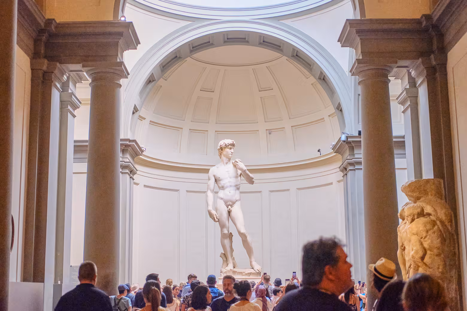 Visitors admiring Michelangelo's David inside the Accademia Gallery, a highlight of Florence's art scene.