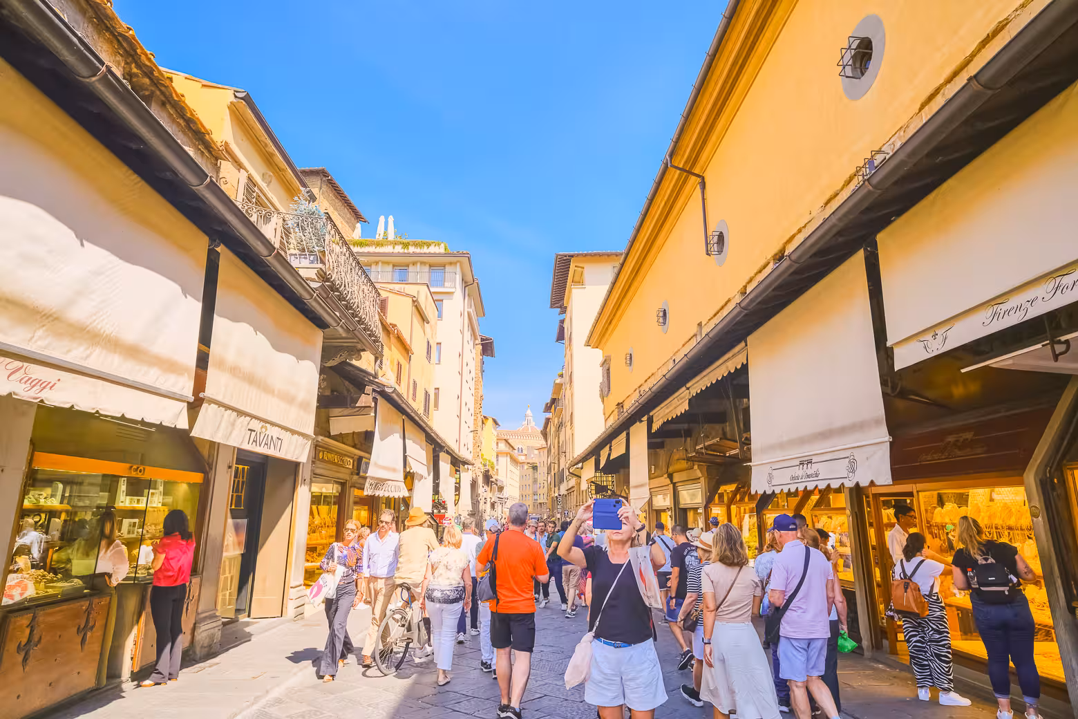 Tourists exploring the vibrant shops on a lively street in Florence, perfect for a small group walking tour experience.