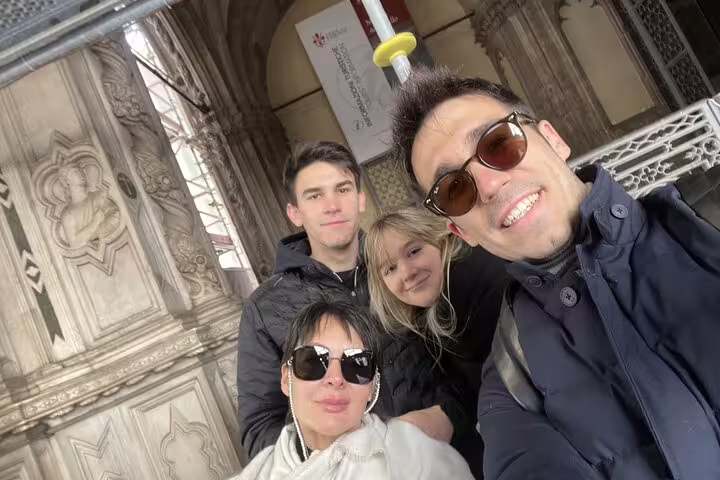 Group of four tourists taking a selfie outside a historic Florence cathedral entrance