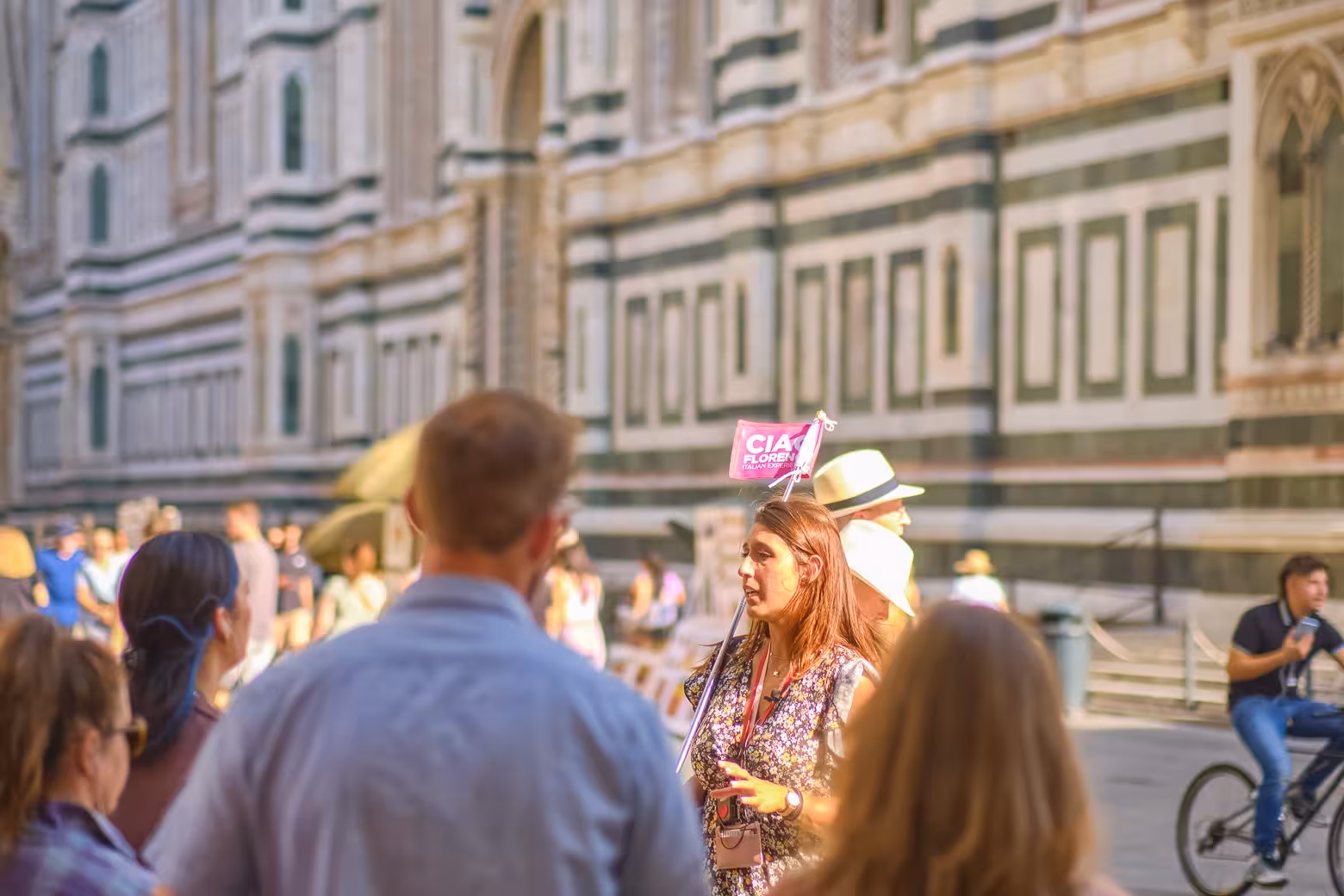 Tour guide leads small group through Florence near iconic architectural landmarks during walking tour.