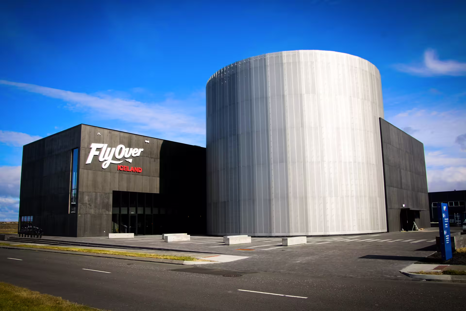 Modern FlyOver Iceland building under blue skies, offering immersive virtual tours and Silfra snorkeling adventures.
