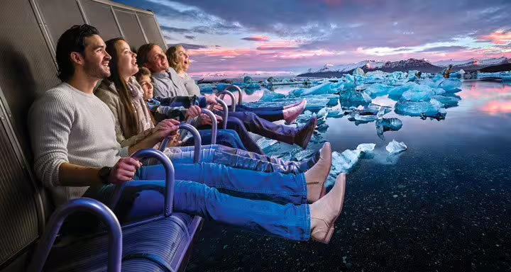 Visitors on FlyOver Iceland ride seats soaring over Jokulsarlon glacier lagoon at sunset