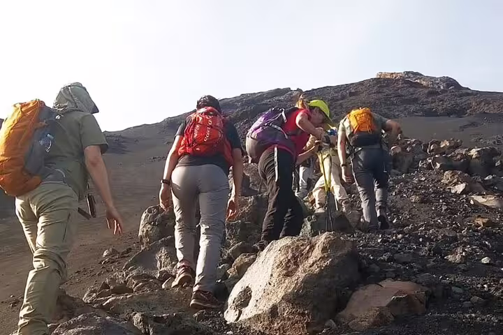 Group of hikers ascending a rocky trail on Fogo Island, showcasing exciting adventure and exploration opportunities.