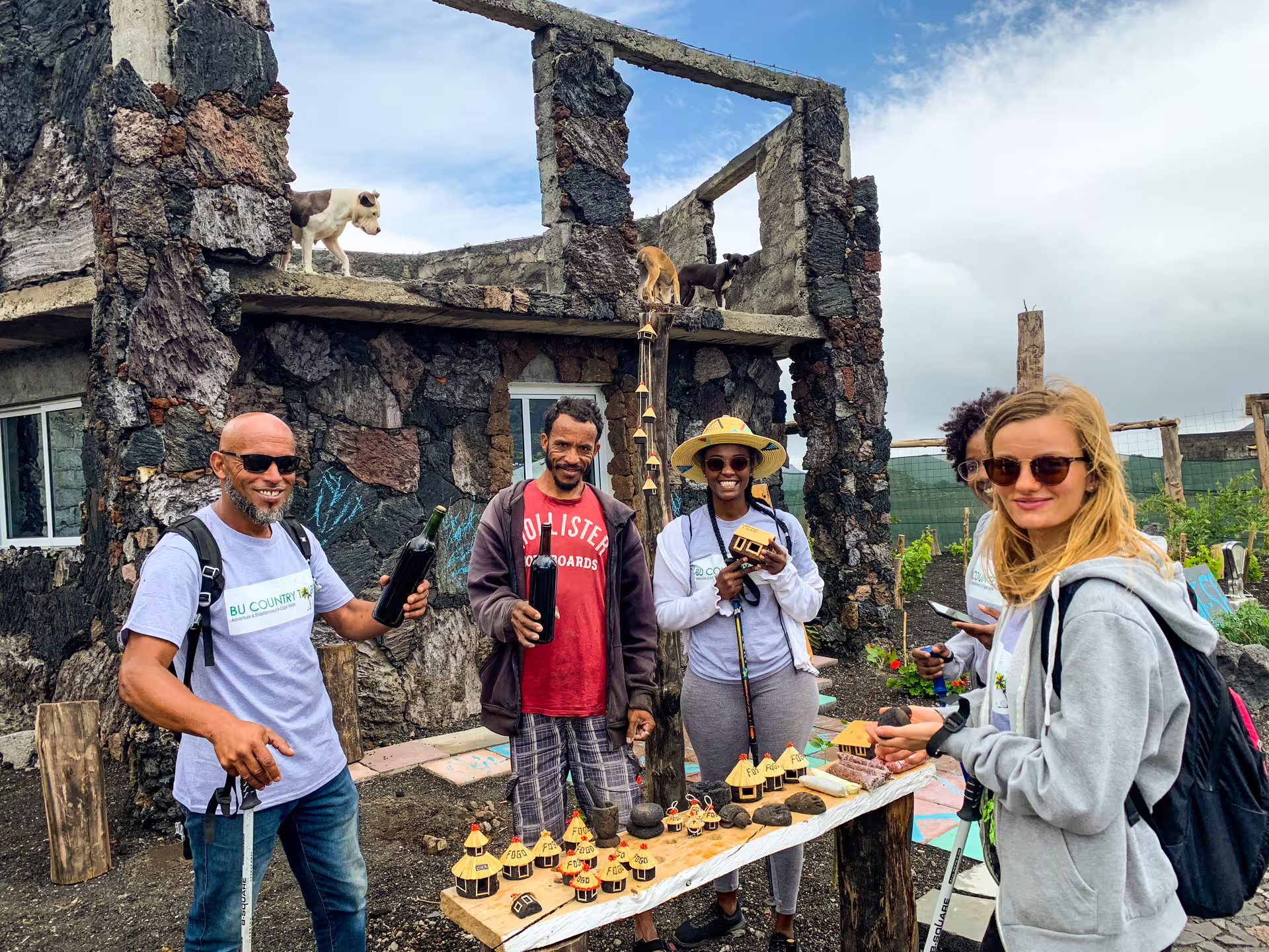 Tourists enjoying local crafts and drinks at a rustic stone building on Fogo Island during a private full-day tour.