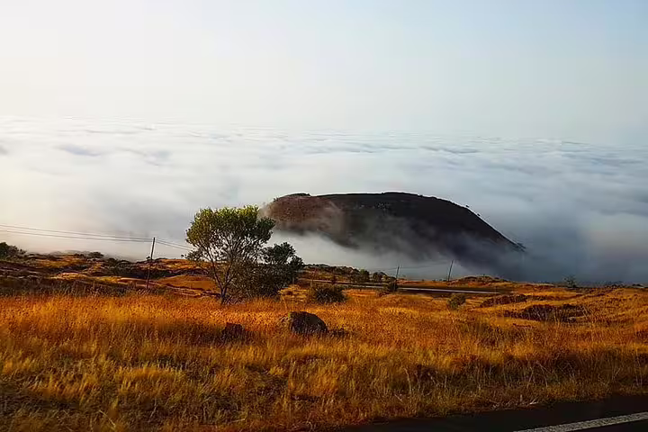 Breathtaking view of Fogo Island's volcano peak emerging above a sea of clouds, ideal for adventurous hikers.