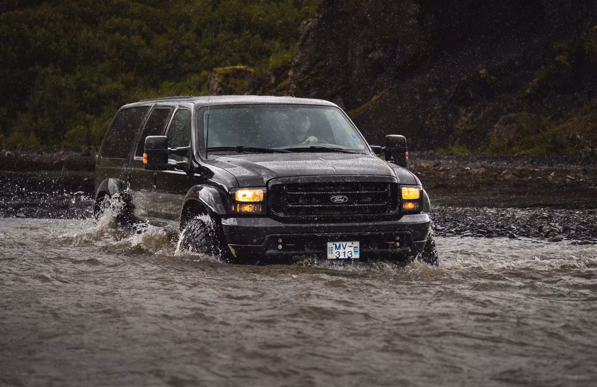 Black Ford Excursion SUV fording a river in Iceland during a Thorsmork full-day tour
