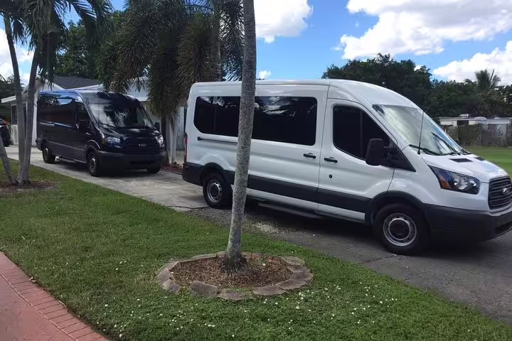 White and black Ford Transit vans available for private group transfer from Belize to BZE Airport