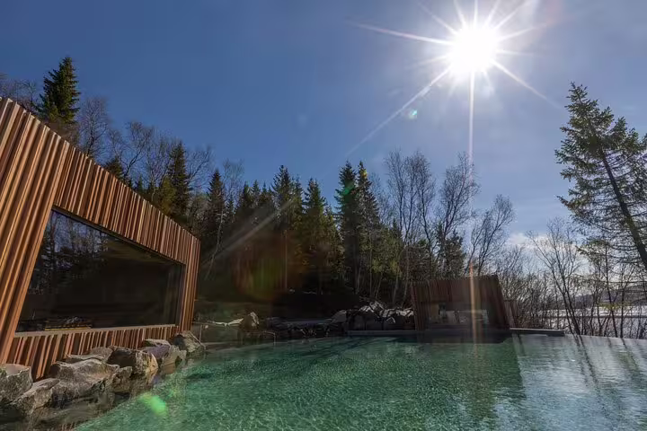 Forest Lagoon outdoor geothermal pool surrounded by pine trees and wooden building in Akureyri, Iceland