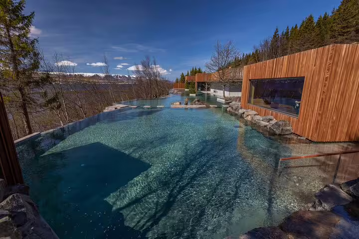 Forest Lagoon geothermal outdoor pool with turquoise water surrounded by trees and mountains near Akureyri Iceland