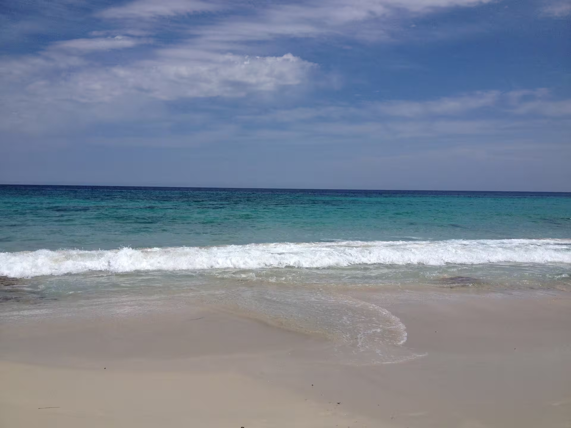 Crystal-clear sea and gentle surf on Formentera, perfect stop on Ibiza to Formentera fast ferry day tour