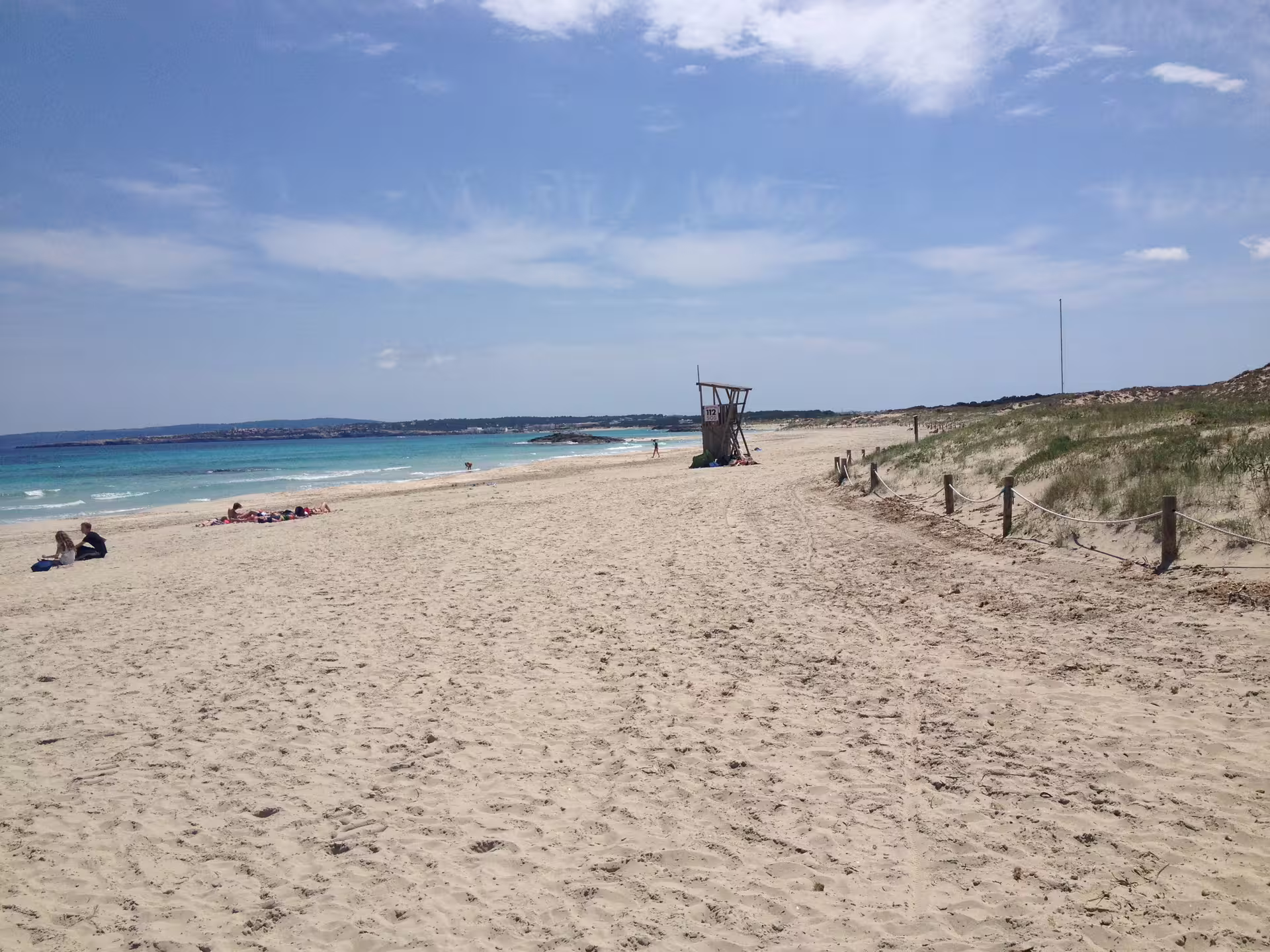 Wide Formentera beach with dunes and lifeguard tower, Ibiza to Formentera day trip with transfers and ferry