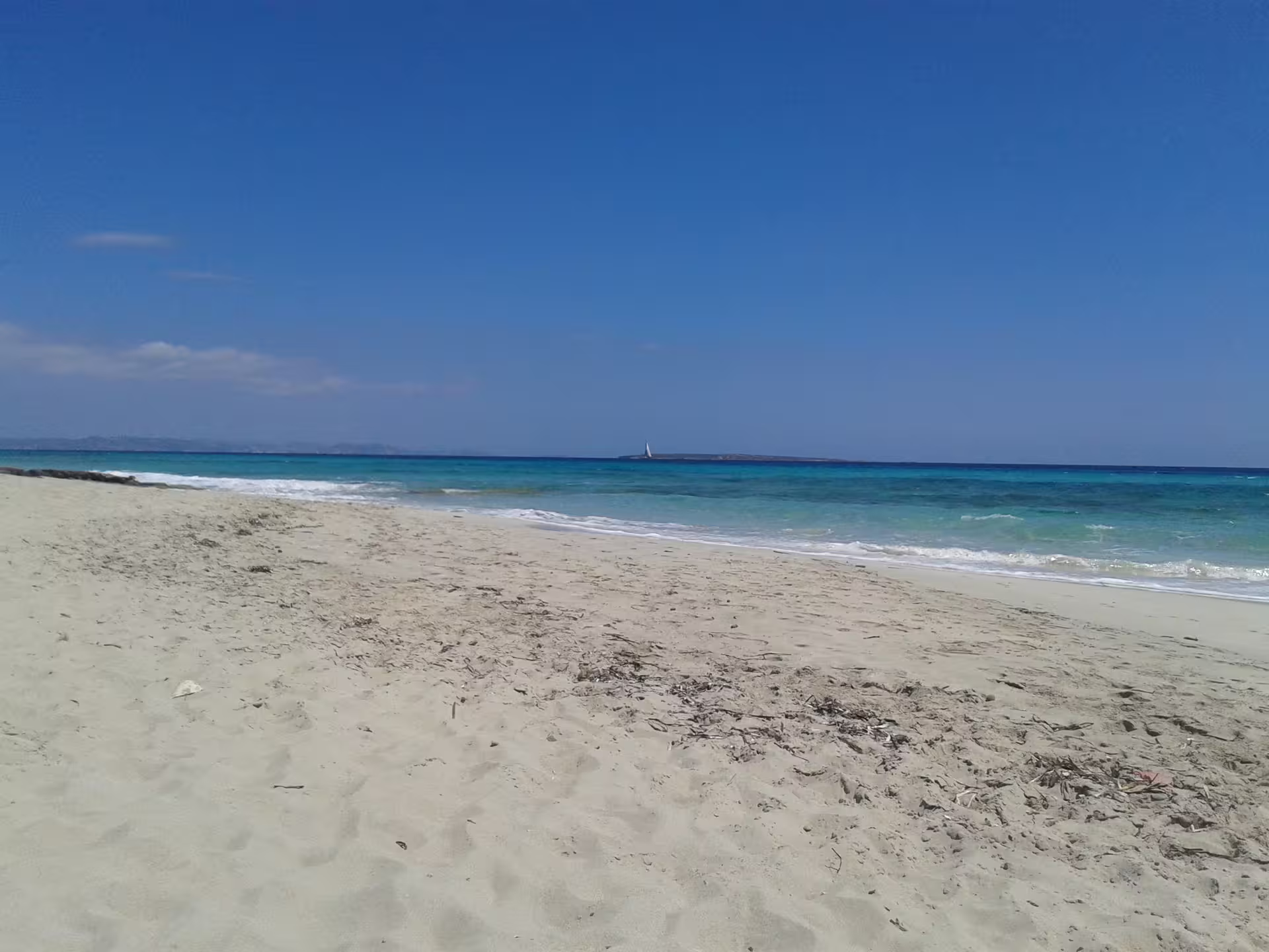 White sand beach and clear blue sea in Formentera on Ibiza day trip by bike with ferry and hotel transfer