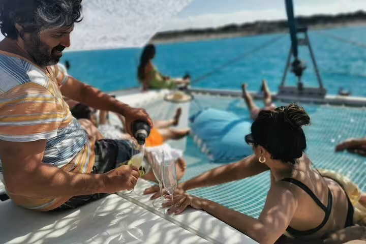 Group enjoying a luxurious catamaran cruise near Formentera and Ibiza, relaxing with drinks and stunning ocean views.