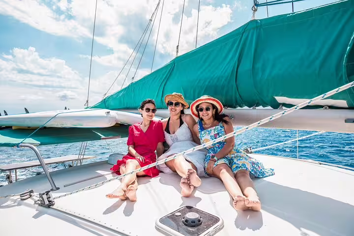 Group of friends relaxing on a catamaran under sunny skies during a Formentera and Ibiza small group sailing adventure.