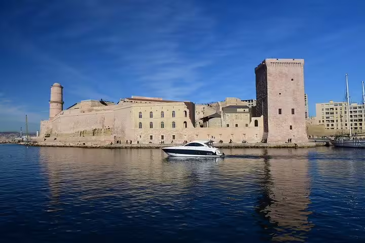 Motor boat passing Fort Saint-Jean fortress at the entrance of Marseille Old Port on a sunny day