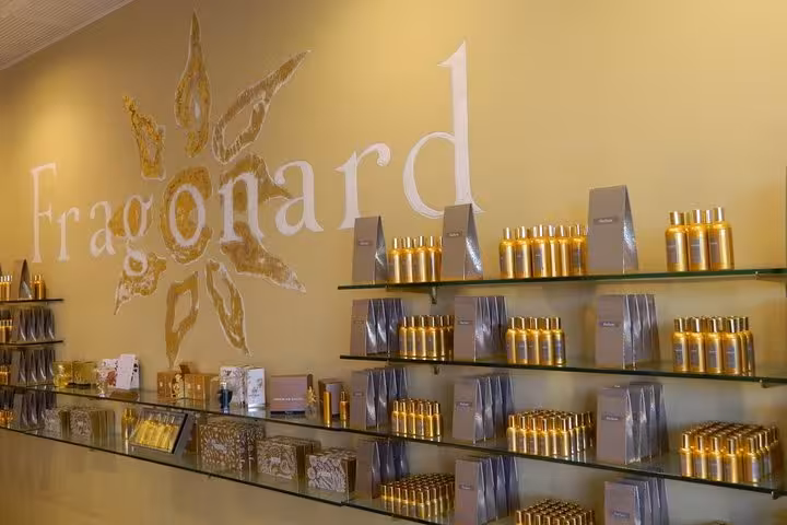 Fragonard perfume shop displaying gold fragrance bottles on glass shelves in Monaco